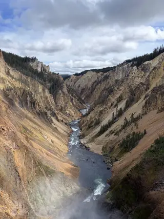 河流穿过陡峭的峡谷，前方升起水汽
